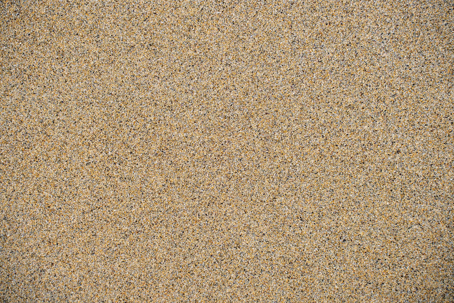 Detailed close-up of textured sand on a beach in Harris, Scotland, perfect for backgrounds.