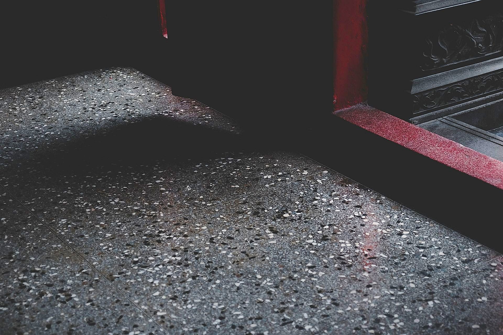 Close-up of a moody stone floor with shadows and texture in a Taiwanese building.
